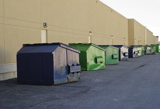 tilted front-load dumpsters being emptied by waste management workers in Buellton CA